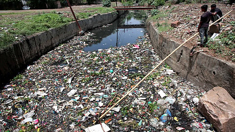 Sanitation workers clean up a large drain in Bhopal, India on World Environment Day.