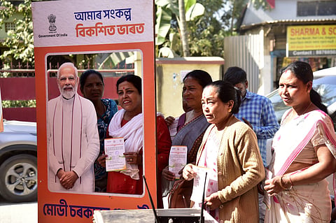 Women pose with a cut-out of India’s prime minister, Narendra Modi, during a 2023 welfare outreach campaign in Guwahati. In the state of Assam, a life insurance programme meant for low-income households is at the centre of a web of fake deaths and forged documents, revealing the fragility of India’s welfare architecture.