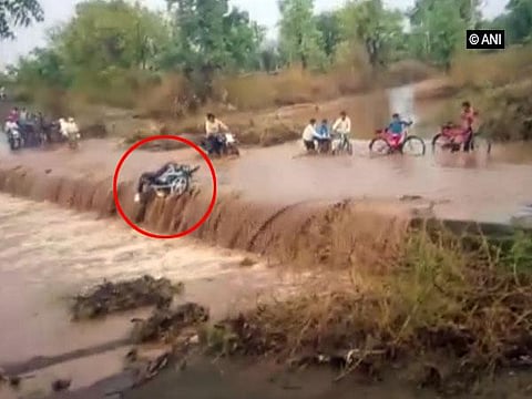 சாலையைக் கடக்க முயன்றபோது வெள்ள நீரில் அடித்துச் செல்லப்பட்ட இருசக்கர வாகன ஓட்டி