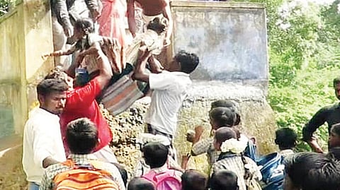 பள்ளி செல்லும் மாணவ, மாணவிகளை 10 அடி உயர கதவணை மீது தூக்கி விடும் பெரியவர்கள்.