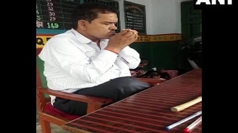 மொஹ்மதாபாத் தொடக்கப் பள்ளியின் வகுப்பறையில் புகைப் பிடிக்கும் ஆசிரியர் | படம்: ஏஎன்ஐ.