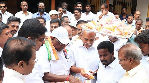 தொண்டர்களுக்கு இனிப்புகள் வழங்கும் நாராயணசாமி