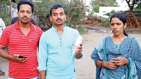 குப்பை கலந்திருந்ததாக கூறப்பட்ட குளுக்கோஸ் பாட்டிலுடன் தேவி உள்ளிட்டோர். படங்கள்: இரா.கார்த்திகேயன்.