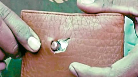 போலீஸ் அதிகாரி விஜயகுமாரின் மணி பர்சை துளைத்த துப்பாக்கி குண்டு.