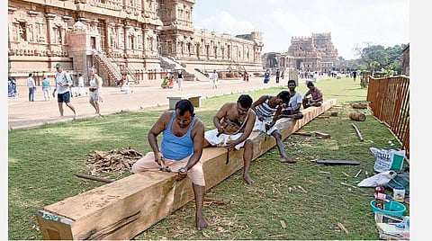 குடமுழுக்கு விழாவையொட்டி தஞ்சை பெரிய கோயிலில் புதிதாக பிரதிஷ்டை செய்வதற்காக கொடி மரத்தை வடிவமைக்கும் பணியில் ஈடுபட்டுள்ள தொழிலாளர்கள்.