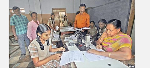கோவை ஆர்எஸ் புரம் கிக்கானி மேல்நிலைப் பள்ளியில் மும்முரமாக நடைபெற்ற பொதுத்தேர்வு விடைத்தாளுடன், முகப்பு பக்கம் இணைக்கும் பணி.