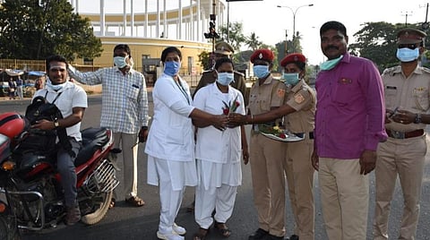 மருத்துவத் துறையினருக்கு பூக்கள் கொடுக்கும் போலீஸார்.