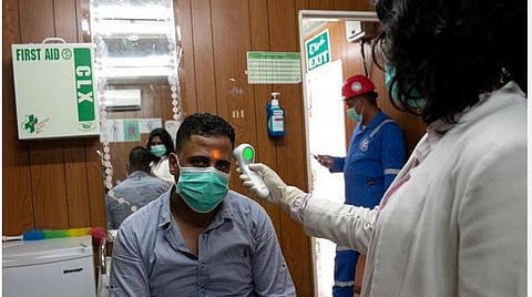 கரோனா வைரஸ் நோய்ப் பரவலைத் தொடர்ந்து,  குவைத்தின் அஹ்மதியில் உள்ள ஒரு கிளினிக்கில், ஒரு இந்தியத் தொழிலாளியை மருத்துவர் பரிசோதிக்கிறார்.