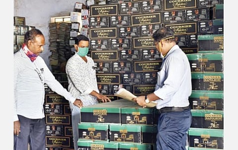 கள்ளச்சந்தையில் மதுபான விற்பனை நடைபெறுவதை கட்டுப்படுத்தும் விதமாக புதுச்சேரி காராமணி குப்பம் பகுதியில் உள்ள அரசு குடோன் ஒன்றில் அடுக்கி வைக்கப்பட்டுள்ள மதுபான பெட்டிகளை நேற்று கணக்கெடுக்கும் கலால் துறையினர். படம்: எம்.சாம்ராஜ்