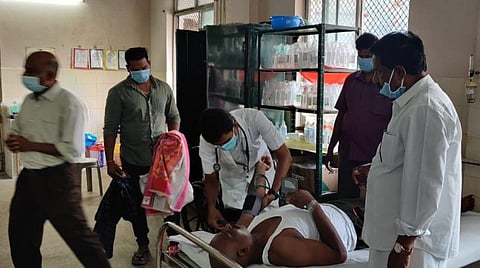 விஷக்குளவி கொட்டியதில் பாதிக்கப்பட்டவருக்கு சிகிச்சை அளிக்கும் மருத்துவர்.