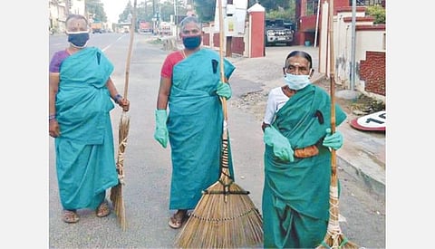 திருப்பூர் குமரன் சாலையில் நேற்று கருப்பு பேட்ஜ் அணிந்து பணியில்  ஈடுபட்ட தூய்மைப் பணியாளர்கள்.