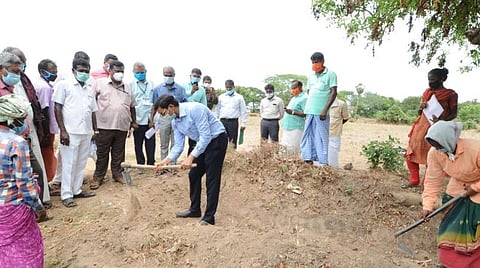மண்வெட்டியால் வாய்க்காலை துார்வாரும் மாவட்ட ஆட்சியர்.