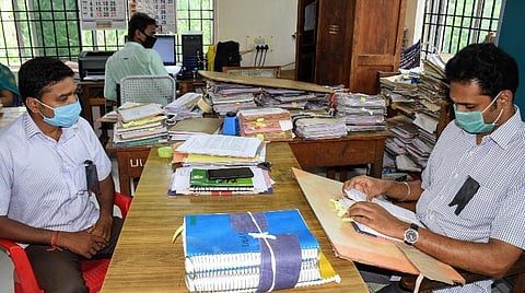 திருச்சி மாவட்ட ஆட்சியர் அலுவலகத்தில் கருப்பு வில்லை அணிந்து பணியில் ஈடுபட்டுள்ள வருவாய்த் துறை ஊழியர்கள்.