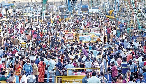 தமிழகத்தில் தளர்வுகளற்ற முழு ஊரடங்கு இன்று கடைபிடிக்கப்படுவதால், சென்னை காசிமேடு மீன்பிடி துறைமுகத்தில் நேற்று மீன் வாங்க வியாபாரிகள் குவிந்தனர்.  படம்: ம.பிரபு