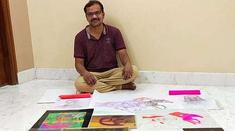 தன் ஓவியங்களுடன் ஓவியர் விஜயகுமார்.