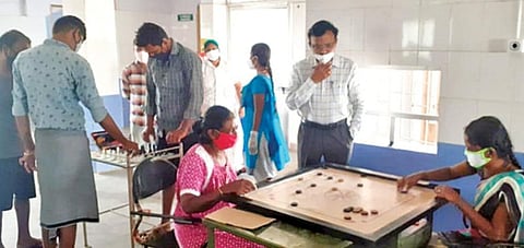 கரூரில் உள்ள சித்த மருத்துவ மையத்தில் கேரம், செஸ் விளையாடும் கரோனா வைரஸ் தொற்றுக்கு சிகிச்சை பெறுவோர். உடன், மாவட்ட சித்த மருத்துவ அலுவலர் எஸ்.காமராஜ்.﻿﻿