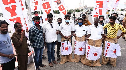 திருச்சி காவிரிப் பாலத்தில் நூதனப் போராட்டத்தில் ஈடுபட்ட இந்திய ஜனநாயக வாலிபர் சங்கத்தினர். | படம்: ஜி.ஞானவேல்முருகன்.