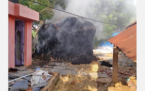 கிருஷ்ணன், முனியசாமி உறவினர்கள் தீ வைத்ததில் பற்றி எரியும் பால்பாண்டி வீடு அருகே இருந்த வைக்கோல் படப்பு.