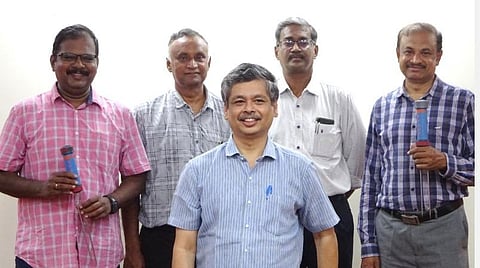 ஈரப்பதங்காட்டி கருவியுடன் விஞ்ஞானிகள்.