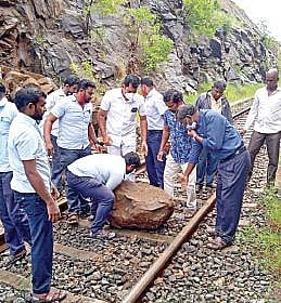 திண்டுக்கல் மாவட்டம் முருகன்பட்டியில் ரயில் தண்டவாளத்தில் பாறை விழுந்ததால் பாதிவழியில் நின்ற வைகை எக்ஸ்பிரஸ். (அடுத்த படம்) ரயில் தண்டவாளத்தில் விழுந்த பாறையை அகற்றும் பணியில் ஈடுபட்ட பணியாளர்கள், பயணிகள்.