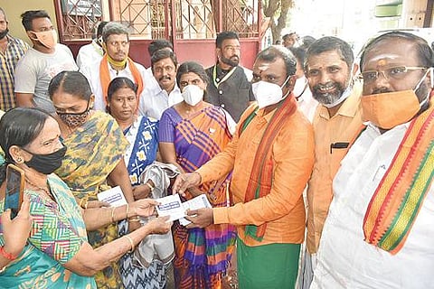 ஈரோட்டில் தெய்வீக தமிழ்ச் சங்கத்தின் சார்பில், பொதுமக்களுக்கு ஆன்மிக நூல்களை பாஜக மாநிலத்தலைவர் எல்.முருகன் வழங்கினார். அருகில் பாஜக மாவட்ட தலைவர் சிவசுப்பிரமணியம் உட்பட நிர்வாகிகள் உள்ளனர்.