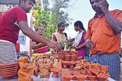 கார்த்திகை தீபத்திருவிழா இன்று கொண்டாடப்படுவதை முன்னிட்டு, பாளையங்கோட்டை தினசரி சந்தையில் அகல்விளக்குகள் விற்பனை மும்முரமாக நடைபெற்றது.(வலது) தூத்துக்குடி பூ மார்க்கெட்டில் போட்டி போட்டு பூக்களை வாங்கிய சிறு வியாபாரிகள் மற்றும் பொதுமக்கள். படங்கள்: மு.லெட்சுமி அருண். என்.ராஜேஷ்
