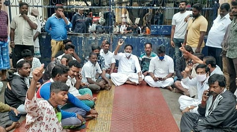 மின்வாரிய அலுவலக வாயிற்கதவை பூட்டி தர்ணாவில் ஈடுபட்டுள்ள அதிமுகவினர்.