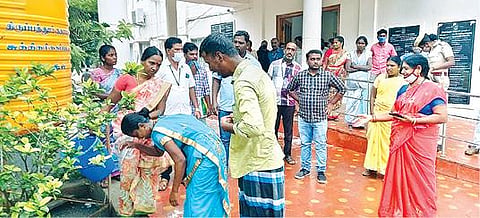 திருப்பத்தூர் ஆட்சியர் அலுவலக வளாகத்தில் தீக்குளிக்க முயன்ற சீனிவாசன் மற்றும் அவரது சகோதரி லாவண்யா மீது தண்ணீரை ஊற்றிய அரசு ஊழியர்கள்.