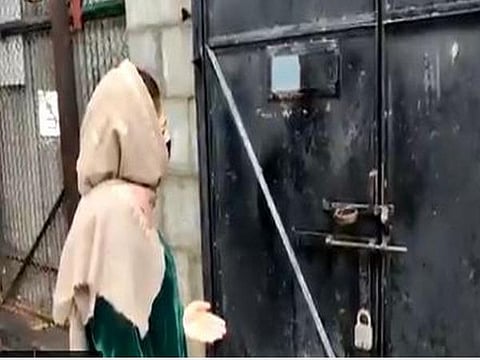 வீட்டுக் காவலில் இருக்கும் போலீஸாரிடம் கதவைத் திறக்கக் கோரும் மெகபூபா முப்தி : படம் உதவி | ட்விட்டர்.