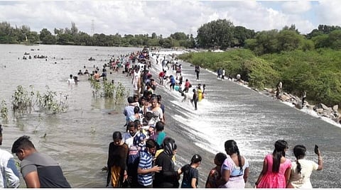 கனமழையால் நிரம்பி வழியும் பழமையான செல்லிப்பட்டு படுகை அணையில் குவிந்துள்ள பொதுமக்கள்.