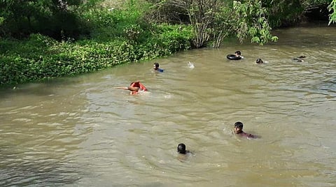 வாய்க்காலில் அடித்துச் செல்லப்பட்ட சிறுவனைத் தேடும் பொதுமக்கள், தீயணைப்பு வீரர்கள்.