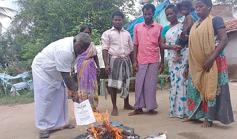 காஞ்சிபுரம் அருகே கூரம் பகுதியில் வேளாண் சட்ட நகல்களை போகித் தீயில் எரித்து வீட்டுக்கு முன்பு போராட்டத்தில் ஈடுபட்ட விவசாயிகள்.