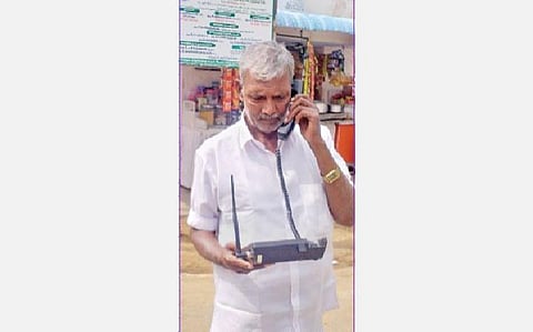 குரங்கணியில் வில்போன் சிக்னலுக்காக தெருவில் நின்று பேசும் காட்சி.