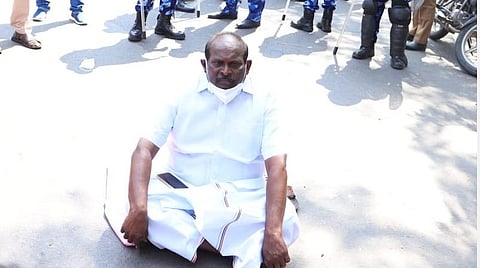 ஆளுநர் மாளிகை அருகே தரையில் அமர்ந்து தர்ணாவில் ஈடுபட்ட அமைச்சர் கந்தசாமி.
