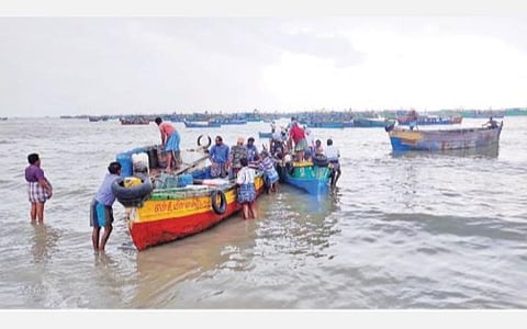 ராமேசுவரம் மீன்பிடி இறங்குதளத்திலிருந்து விசைப்படகுகளுக்கு தேவையான டீசல், ஐஸ் கட்டிகளை நாட்டுப் படகில் ஏற்றிச் செல்லும் மீனவர்கள்.