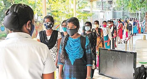 9, 11-ம் வகுப்புக்கும் நேற்று பள்ளிகள் திறக்கப்பட்டன. குரோம்பேட்டை அரசு பள்ளியில் மாணவிகள் உடல் வெப்பநிலை பரிசோதிக்கப்படுகிறது.படங்கள்: எம்.முத்துகணேஷ்