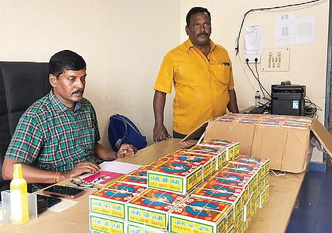 கைப்பற்றிய  மூக்குப்பொடி டப்பாக்களுடன் சுங்கத் துறை அதிகாரிகள்.