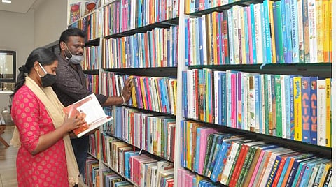 நூலகத்தில் புத்தகங்களைத் தேர்வு செய்யும் வாசகர்கள்.