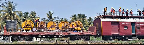 சேலம்-விருத்தாசலம் ரயில் பாதையை மின்மயமாக்கும் பணியில், அயோத்தியாப்பட்டணம் பகுதியில் ரயில் பாதையோரம் அமைக்கப்பட்டுள்ள மின் கம்பங்களில் உயர் மட்ட மின்சார கேபிள் பொருத்தும் பணி நடைபெற்று வருகிறது. இதற்காக பிரத்யேக ரயில் மூலம் இப்பணி மேற்கொள்ளும் ரயில்வே ஊழியர்கள்.                                                                 படம்: எஸ்.குரு பிரசாத்