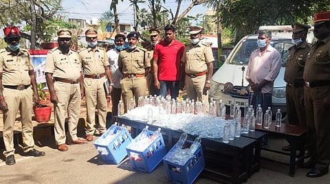 காரில் கடத்தப்பட்ட சாராயத்துடன் காவல்துறையினர் .