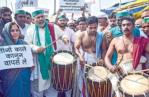 வேளாண் சட்டங்களை எதிர்த்து டெல்லியில் விவசாயிகள் போராட்டம் நடத்தி வருகின்றனர். டெல்லி உ.பி. கேட் பகுதியில் நேற்று நடந்த போராட்டத்தில் கேரள மாநிலத்தின் கலைஞர்கள் செண்டை மேளம் இசைத்தனர். பிகேயு விவசாய சங்க செய்தித் தொடர்பாளர் ராகேஷ் டிகைத் அவர்களுடன் சேர்ந்து மேளம் இசைத்தார். படம்: பிடிஐ