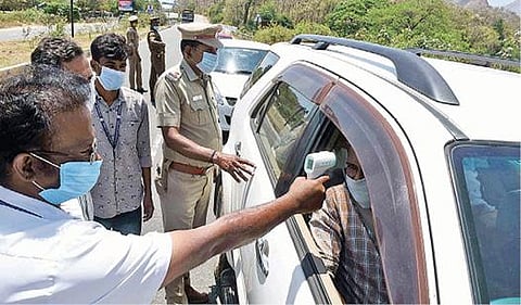 காரில் வந்த பயணியிடம் உடல் வெப்பநிலையை பரிசோதித்த சுகாதாரத் துறையினர்.  படங்கள்: ஜெ.மனோகரன்