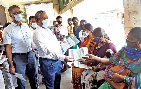 கோவை காந்திபுரம் நகரப் பேருந்து நிலைய வளாகத்தில் நேற்று பொதுமக்களுக்கு கரோனா நோய் தடுப்பு குறித்த துண்டுப் பிரசுரங்களை விநியோகித்த மாவட்ட ஆட்சியர் கு.ராசாமணி. அருகில், மாநகராட்சி ஆணையர் பெ.குமாரவேல் பாண்டியன் உள்ளிட்டோர்.  படம்:ஜெ.மனோகரன்