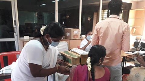 தேர்தல் பணி பயிற்சி வளாகத்தில் உள்ள தடுப்பூசி மையத்தில் தடுப்பூசி செலுத்திக் கொள்ளும் பெண் அலுவலர்.
