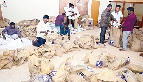 தேர்தல் பணிக்காக வாக்குச் சாவடி மையங்களுக்கு தேவைப்படும் பொருட்களை சாக்கு பையில் போட்டு அனுப்பும் பணியில்  ஈடுபட்டுள்ள தேர்தல் அலுவலர்கள். இடம்: திருவல்லிக்கேணி என்.கே.டி பள்ளி.படம்: க.ஸ்ரீபரத்