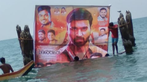 புதுச்சேரி கடலில் வைக்கப்பட்டுள்ள நடிகர் தனுஷின் பேனர்.