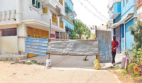 கரோனா பாதிப்பால் தகரம் வைத்து அடைக்கப்பட்டுள்ள மதுரை பைபாஸ் சாலை நேரு நகர் ராமகிருஷ்ணா குறுக்குத் தெரு. படம்: எஸ்.கிருஷ்ணமூர்த்தி