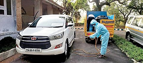 மாமல்லபுரம் விருந்தினர் மாளிகையில் தங்கியுள்ள திருப்போரூர் தொகுதி தேர்தல்  பார்வையாளர் வாகனத்தின் மீது கிருமிநாசினி தெளிக்கும் சுகாதாரப் பணியாளர்.