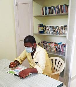 சேத்துப்பட்டில் உள்ள கரோனா பராமரிப்பு மையத்தில் புத்தகத்தை வாசிக்கும் இளைஞர்.