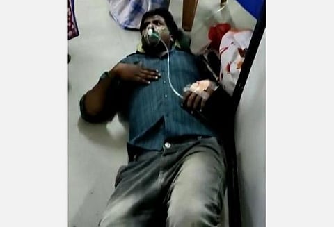படுக்கை இல்லாமல் தரையில் படுத்து சிகிச்சை பெறும் கரோனா தொற்றாளர்.